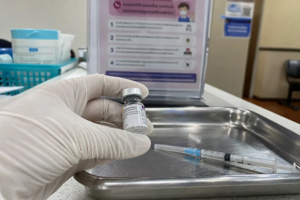 En handskbeklädd hand håller en vaccinspruta och ampull på en bricka, med koppling till att HPV-cancer rusar bland män änd...