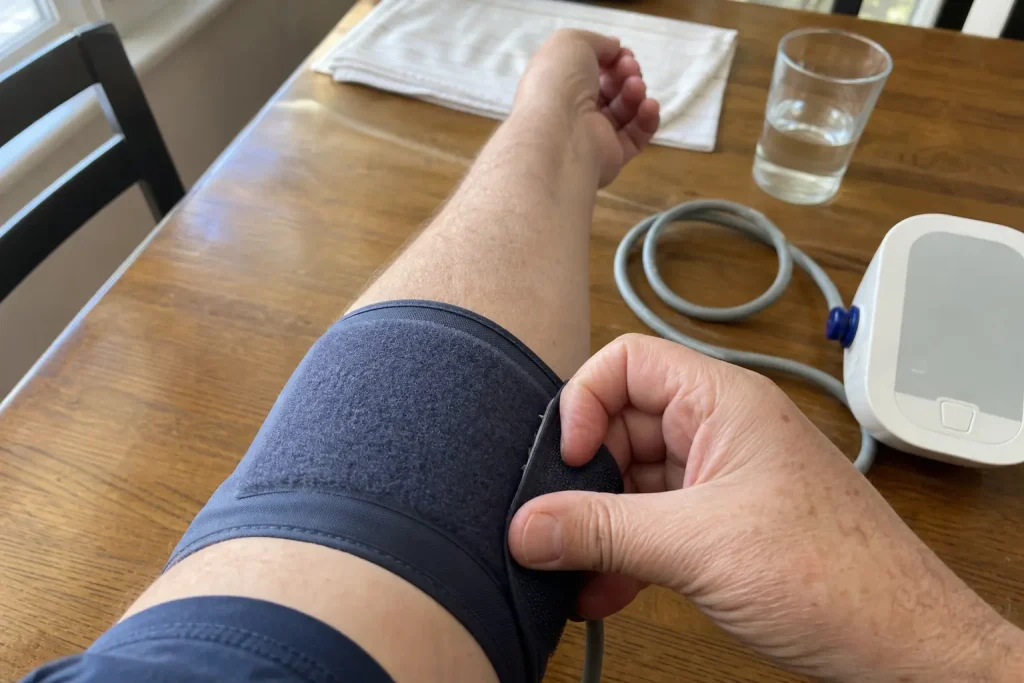 Person mäter blodtrycket hemma vid köksbordet, relevant då 0,5 miljon har T2DM utan att veta om det och 0,8 miljoner har k...